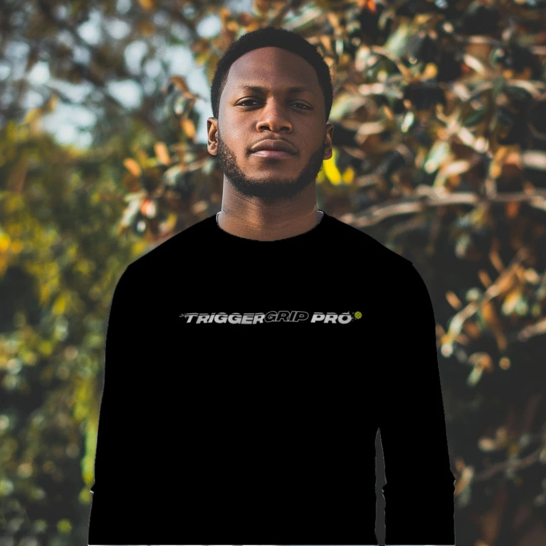 Man wearing black TriggerGrip Pro long sleeve pickleball shirt outdoors